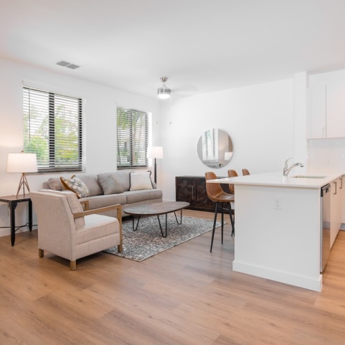 a kitchen and a living room with a couch and a chair